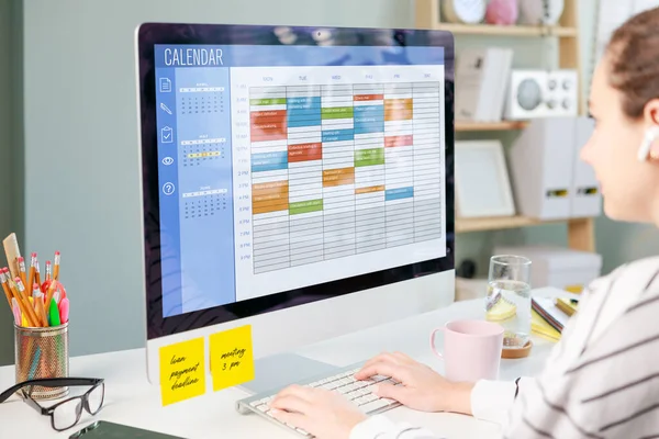 Freelancer woman using calendar on computer to improve time management, plan appointments, events, tasks and meetings efficiently, improve productivity, organize week day and work hours