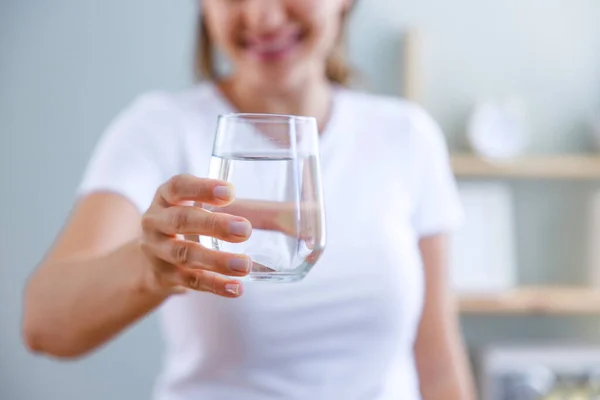 Een Glimlachende Jonge Vrouw Met Een Vol Glas Water Haar — Stockfoto
