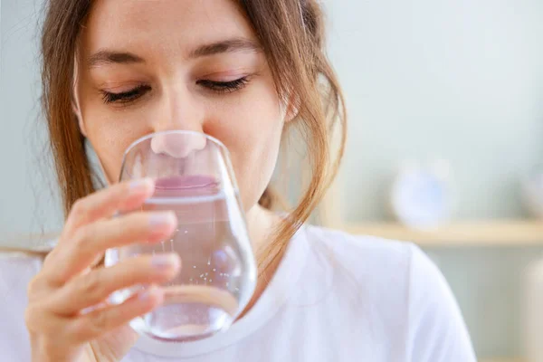 若い女性は家で水を飲む 十分な水の概念を飲むことの健康上の利点 — ストック写真
