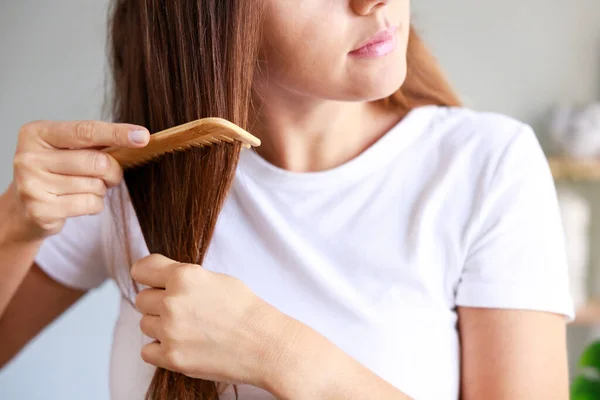 Молодая Женщина Каштановыми Прямыми Волосами Расчесывает Волосы Дома — стоковое фото