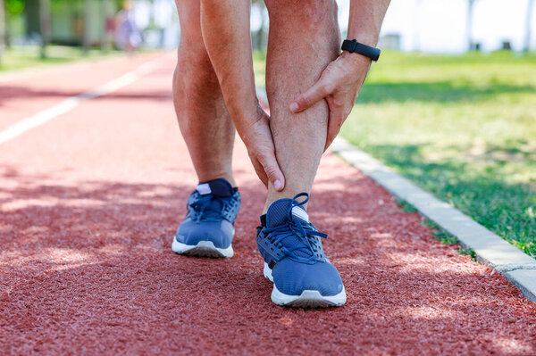 Молодой человек, страдающий от травмы лодыжки во время тренировки