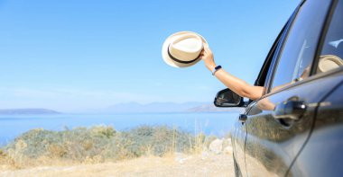 Deniz manzaralı mutlu bir tatil yolculuğu. Tatil yolunda araba kullanan mutlu bir kadın.