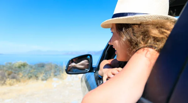 Szczęśliwa Młoda Kobieta Kierowca Słomkowym Kapeluszu Patrząc Okna Samochodu Zewnątrz — Zdjęcie stockowe