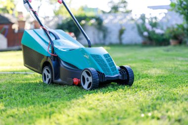 Arka bahçedeki çim biçme makinesi.