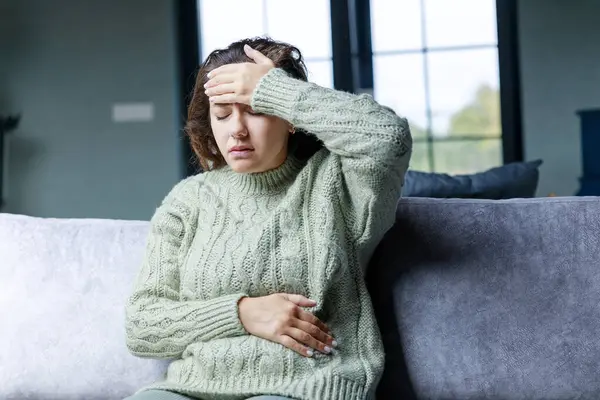 ソファに座って頭痛の若い女性 一般的な健康問題の概念 片頭痛 — ストック写真