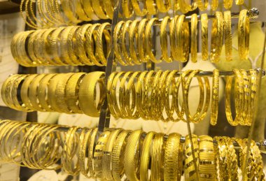 Kuyumcunun vitrininde altın bilezikler var.