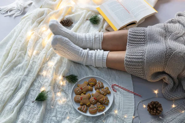 Young woman wearing woolen socks on cold winter weekend. Christmas, relaxation concept