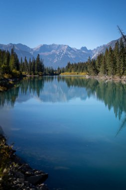 Banff Ulusal Parkı 'nda nehir kıyısında dağ yansıması.