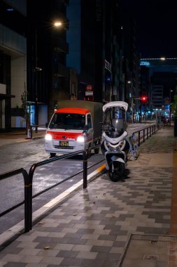 Orta Tokyo 'da arka sokaktan geçen küçük bir Kei kamyonu.