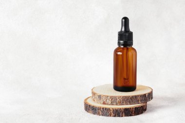 Ahşap kesiğinde tıbbi ve kozmetik amaçlı cam damlalar. Doğal kozmetik ve önemli eko-ambalaj, SPA konsepti.