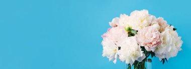 Mavi arka planda bir buket pembe şakayık vazosu. Anneler günü, sevgililer günü, doğum günü kutlaması konsepti. Tebrik kartı. Boşluğu kopyala, üst görünüm