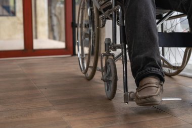 Tekerlekli sandalyedeki adama yakın çekim. Sağlık konsept rehabilitasyon merkezinde tekerlekli sandalyedeki yaralı adam..