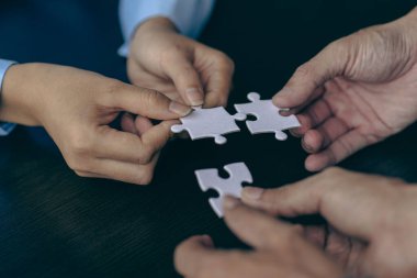 İnsanlar elinde yapboz tutuyor. İş çözümleri, başarı ve strateji. Yapboz yapan bir grup iş adamı.