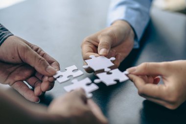 İnsanlar elinde yapboz tutuyor. İş çözümleri, başarı ve strateji. Yapboz yapan bir grup iş adamı.