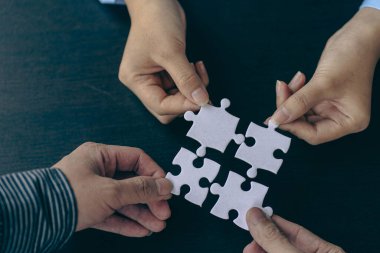 İnsanlar elinde yapboz tutuyor. İş çözümleri, başarı ve strateji. Yapboz yapan bir grup iş adamı.