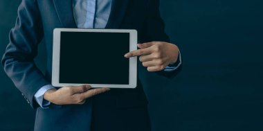 İş kadını elinde boş siyah ekranlı bir tablet tutuyor ve tablet gerekliliklerini sunuyor. Bir kadın ekranda kendi başına mesaj atabileceği en son güncellemeleri gösteriyor..