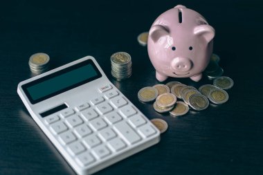 Domuz kumbarası, hesap makinesi, para yığını, kumbaralar para tasarrufu, bankacılık, yatırımlar, mevduatlar, muhasebe kavramları