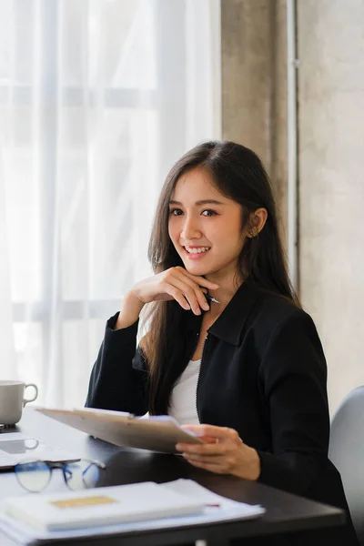 stock image Asian businesswoman working on finance and business information at the officeYoung people are analyzing plans using data from paper graphs.