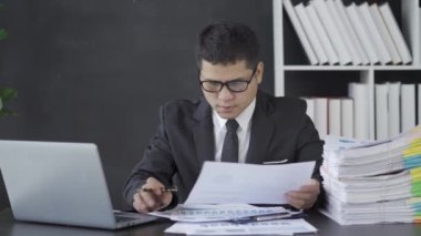 İş yerindeki iş belgelerini inceleyen bir işadamı grafik çizelgeleriyle mali raporlama yapan bir muhasebeci. Finansal iş fikri 4k 25ps