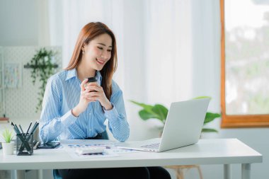 Finans ve hesap makinesinde çalışan Asyalı iş kadını ofis teknoloji piyasası ve finansal kavramlarda kağıt belgelerle dizüstü bilgisayarla çalışıyor.