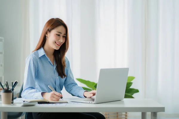 stock image Asian businesswoman working in finance and calculator working with laptop computer with paper documents at office Technology market and financial concepts