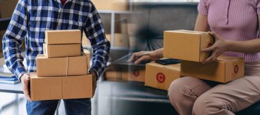 Çevrimiçi iş fikri, genç girişimci, evde dizüstü bilgisayarla ve akıllı telefonla çalışıyor, siparişleri alıyor ve paketleri teslim ediyor..