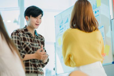 Genç mutlu Asyalı iş adamı yaratıcı ekip beyin fırtınası toplantısını başlatmak için birlikte çalışıyor. Başarılı iş ortağı çalışma konsepti.