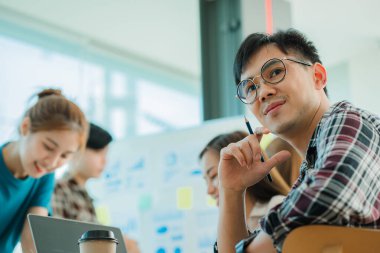 Genç mutlu Asyalı iş adamı yaratıcı ekip beyin fırtınası toplantısını başlatmak için birlikte çalışıyor. Başarılı iş ortağı çalışma konsepti.