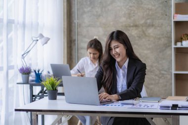 Mali analiz yapan iki Asyalı kadın. Toplantıda fikir alışverişinde bulunan iki iş kadını..