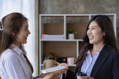 Mali analiz yapan iki Asyalı kadın. Toplantıda fikir alışverişinde bulunan iki iş kadını..