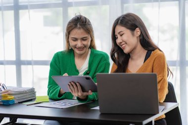 Mali analiz yapan iki Asyalı kadın. Toplantıda fikir alışverişinde bulunan iki iş kadını..