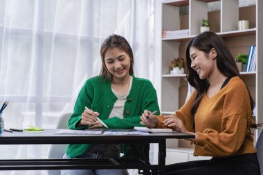 Mali analiz yapan iki Asyalı kadın. Toplantıda fikir alışverişinde bulunan iki iş kadını..