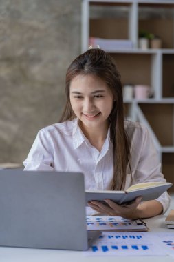 Yatırım grafiklerini analiz eden bir iş kadını. Ofisteki hesap makinesi muhasebesi ve teknolojisini hesaplıyor.