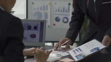 Asya 'daki iş adamları, ofisteki oda piyasası tartışmalarında verimliliği artırmak için beyaz tahtadaki grafikleri analiz ediyorlar. Beyin fırtınası takım çalışması iş dünyası toplantısı