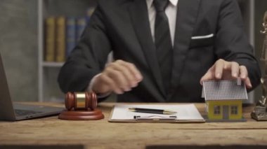 Ev müzayedesi fikri, iş adamı elinde çekiç, yanında da bir ev tutuyordu. Avukatın el kamerasında emlak çekiç evi ve ofis fikri vardı..