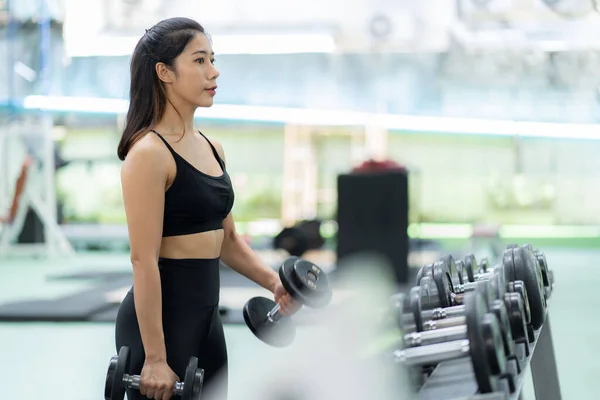 ウェイトトレーニングフィットネスジムで運動するアジアの女性 重量挙げ 強い体 スポーツウェアで ヘルスケアのモチベーションコンセプト ジムで笑顔 — ストック写真