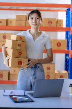 Küçük işletme girişimi KME Sahibi Asyalı Kadın Laptop Online Siparişleri Kutularla çalışan ürünleri satıyor. Evde ve çevrimiçi KOBİ 'de bağımsız olarak çalış