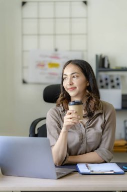 Muhasebe ya da Tasarruf Şirketi ile teknik fiyat grafiklerini ve göstergeleri analiz etmeye çalışan Asyalı kadın muhasebeci..