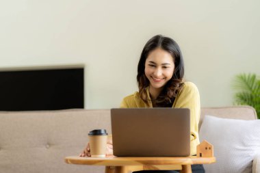 Ev fikirlerinde iş, muhasebe veya tasarruf yapan bir ekiple birlikte, teknik fiyat grafiklerini ve göstergeleri analiz etmek için dizüstü bilgisayar kullanan Asyalı kadın muhasebeci..