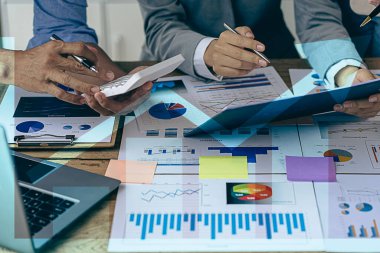 İş adamları veri grafiklerini analiz etmek ve tartışmak ve tartışmak için toplanıyor. Finansal raporlar, mali danışmanlar, takım çalışması ve muhasebe kavramları ofis masası harcamaları