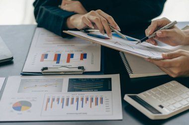 İş adamları veri grafiklerini analiz etmek ve tartışmak ve tartışmak için toplanıyor. Finansal raporlar, mali danışmanlar, takım çalışması ve muhasebe kavramları ofis masası harcamaları