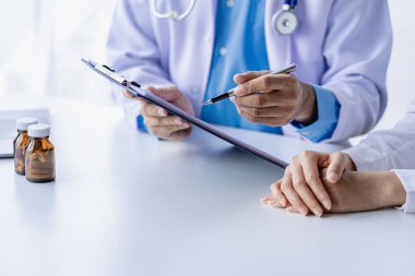 Doktorlar ve hastalar oturup hastalarla ilaçlar hakkında konuşurlar. Hastanenin penceresinin yanındaki masada kadın doktor konuşuyor, küçük hastayı muayene ediyor ve doktor not alıyor..
