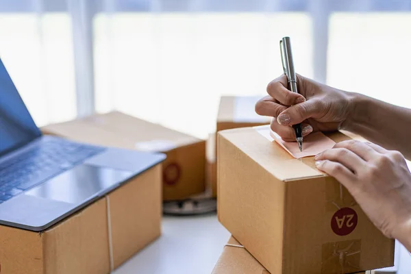 stock image SME business, online sales at home, Asian woman working with boxes and laptops to take orders from customers, parcel delivery concept, online business SME