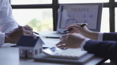 Emlakçılar müşterilere ev kredisi sözleşmesi sunuyor. ve müşteriler için sigorta zinciri ve ev oyuncağı kopyaları banka kredi anlaşmaları ya da gayrimenkul kiralamaları. Kavram.