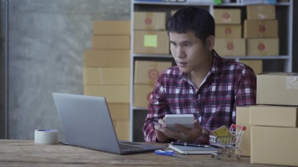 Νεαρός Μιλάει Στο Smartphone Και Χρησιμοποιεί Φορητό Υπολογιστή Για Πουλήσει — Αρχείο Βίντεο