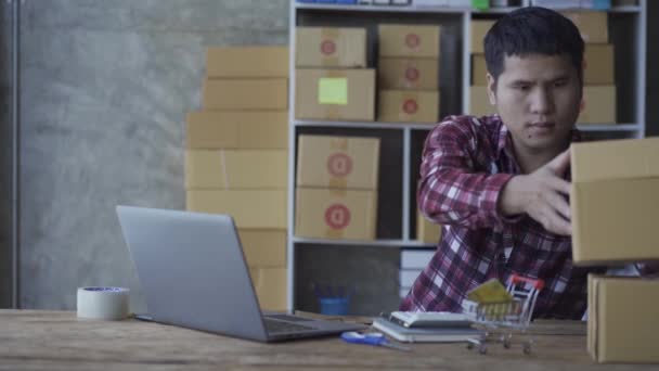 Молодой Человек Разговаривает Смартфоне Использует Ноутбук Продажи Продуктов Интернете Дому — стоковое видео