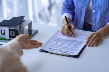 Emlakçılar ev satın alma ofisindeki müşterilere ev ve sigorta faiz oranı sözleşmeleri öneriyor..