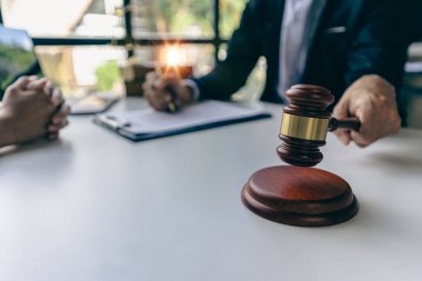 İş adamları ve avukatlar sözleşme belgelerini tartışıyor. Antlaşma Kanunu. İş sözleşmesi ve yasal belgeler ve yanında adalet terazisi ve çekiç bulunan ortak davalar hakkında bilgi edinin.