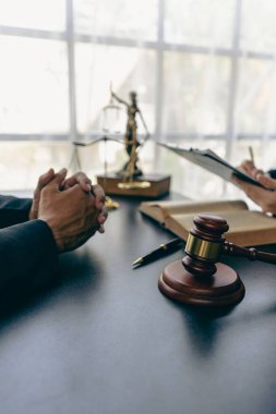 İş adamları ve avukatlar sözleşme belgelerini tartışıyor. Antlaşma Kanunu. İş sözleşmesi ve yasal belgeler ve yanında adalet terazisi ve çekiç bulunan ortak davalar hakkında bilgi edinin.