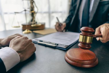 İş adamları ve avukatlar sözleşme belgelerini tartışıyor. Antlaşma Kanunu. İş sözleşmesi ve yasal belgeler ve yanında adalet terazisi ve çekiç bulunan ortak davalar hakkında bilgi edinin.